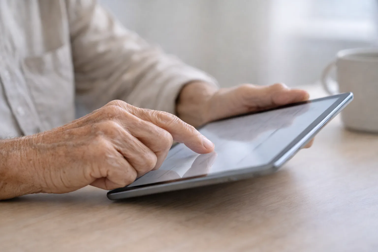 Imaxe dunha tablet e unhas mans tocando a mesma